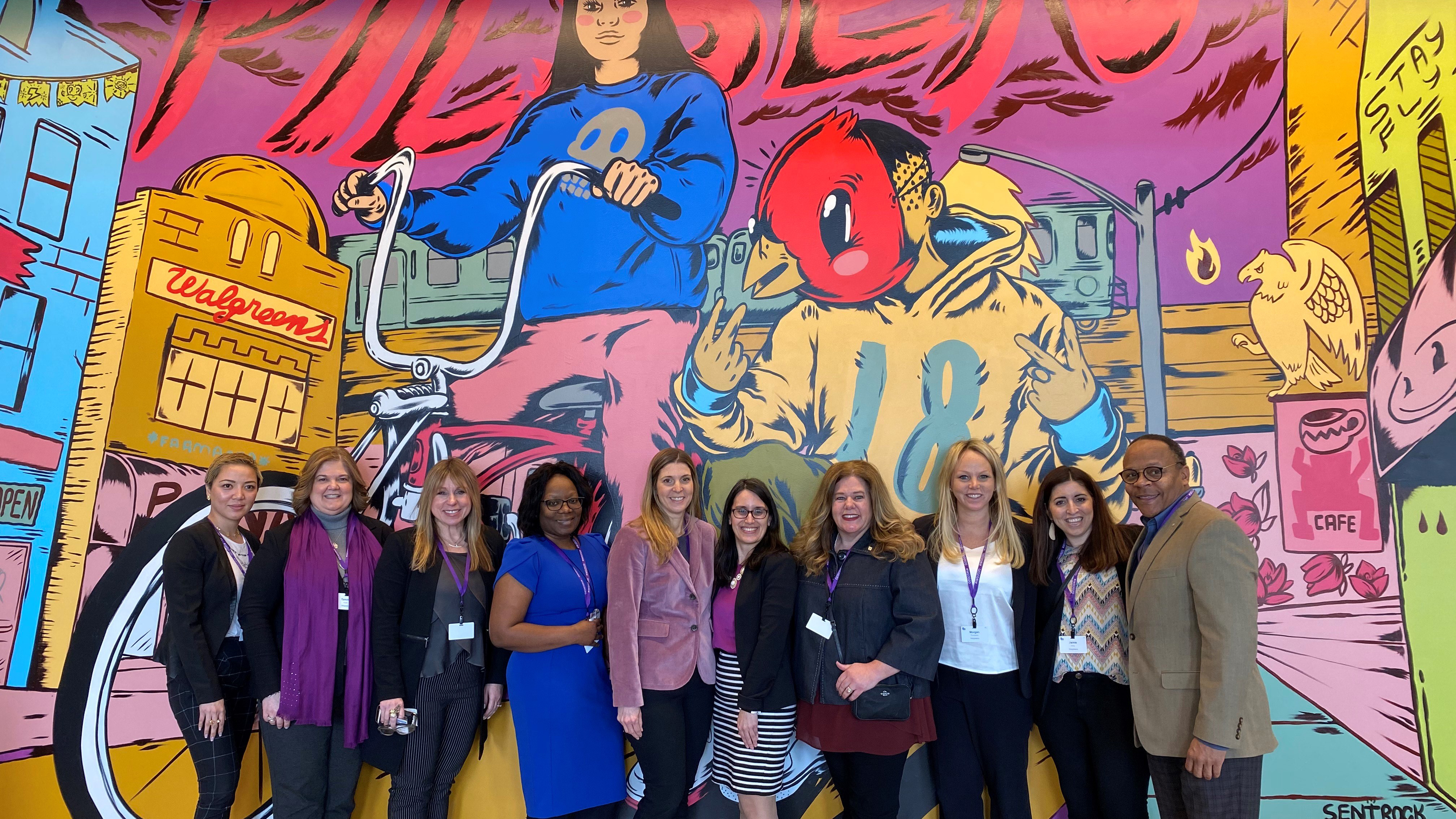 Women standing in front of mural background