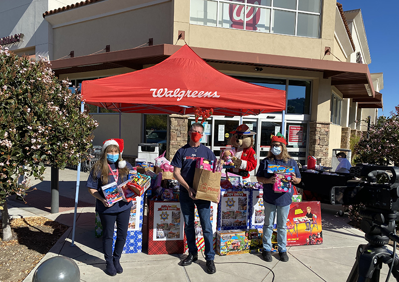 Store manager Jerry Pira (center) with customer service associates Vicki Pinto (left) and Lorraine Mikels and some of the toys collected in Thousand Oaks, Calif.