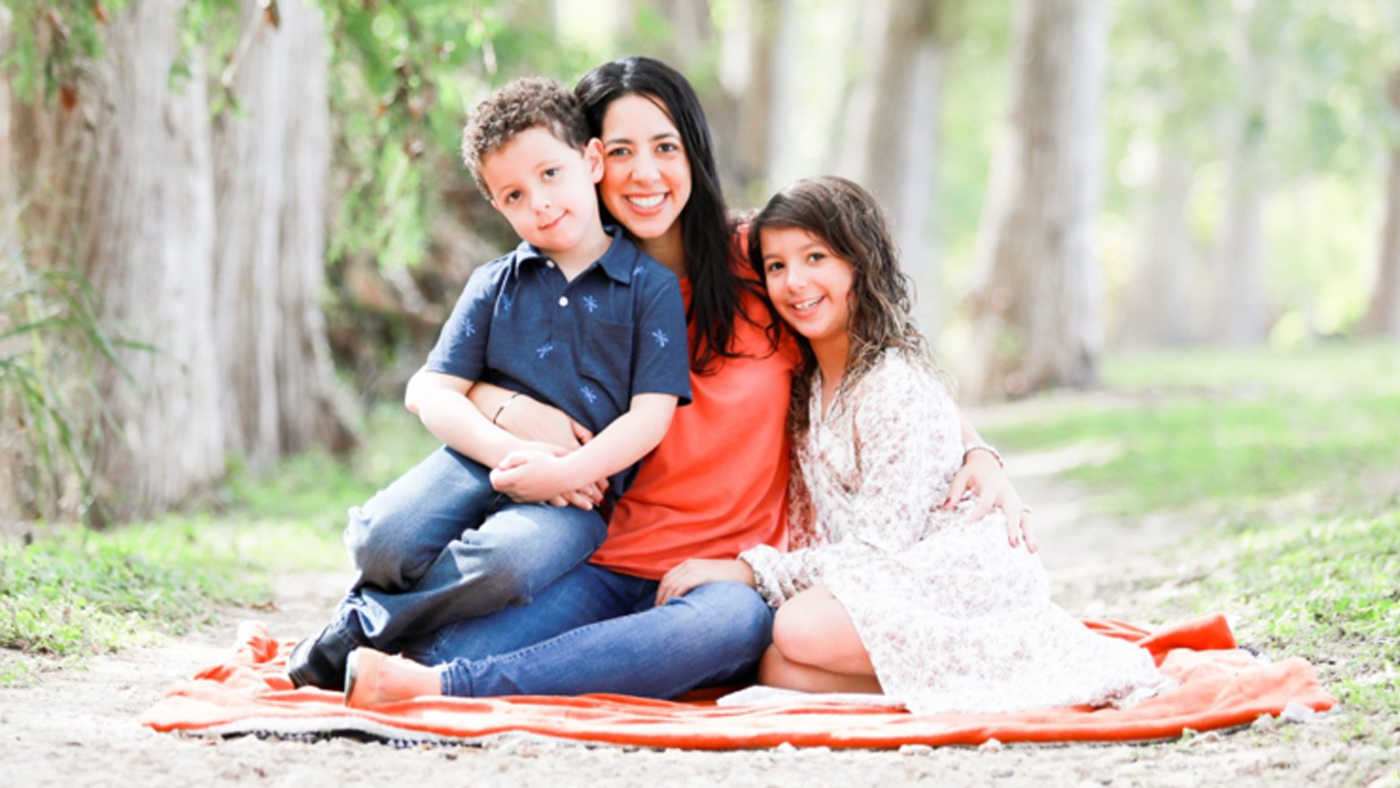 Laly Halvern and her two children on a blanket in the woods