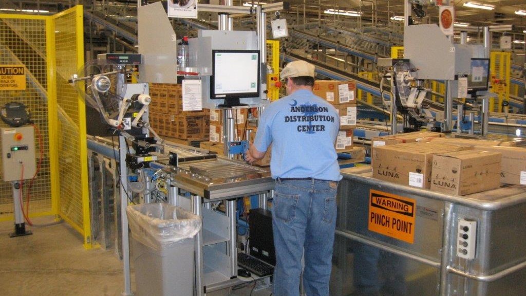 a distribution center worker checks boxes