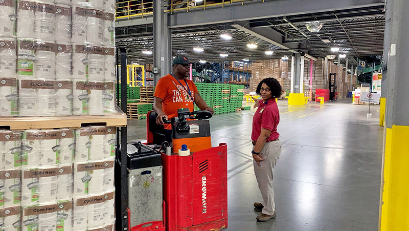 General warehouse team member Clayton Adams (left) and group supervisor Andrea Moore move a pallet stacked with paper towels at the Walgreens distribution center in Jupiter, Fla.
