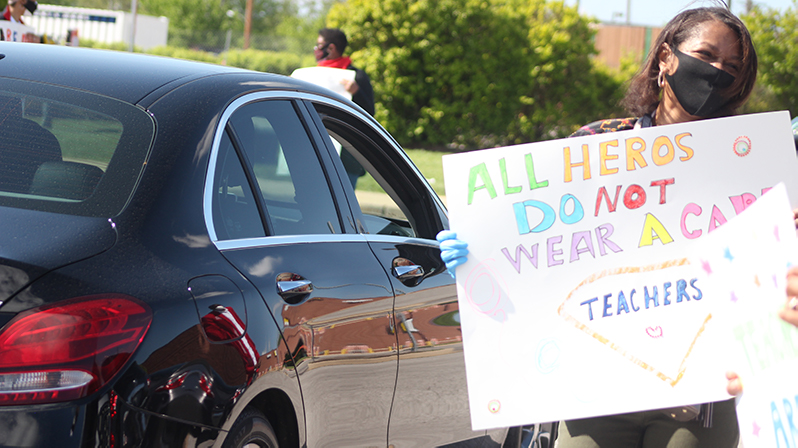 Holding a sign recognizing teachers in Jennings