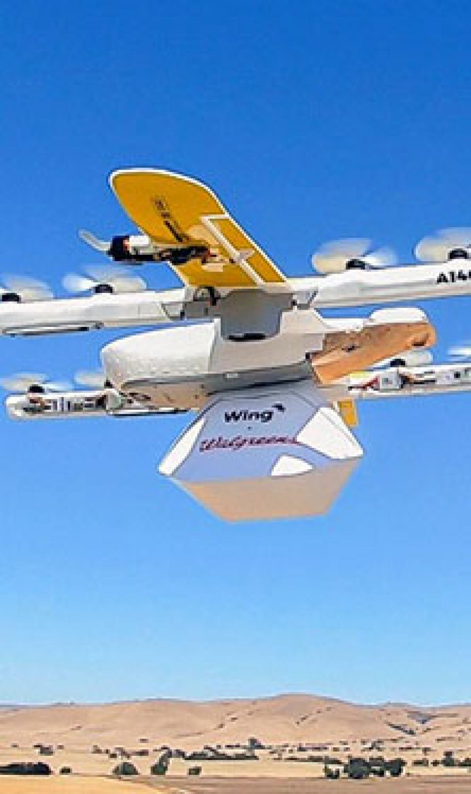Picture of a flying yellow and white drone, testing the on-demand drone delivery service