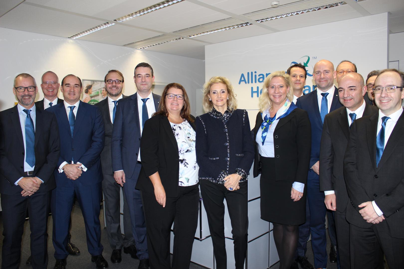 Team members from WBA and McKesson standing infront of an Alliance Healthcare Germany ogo 