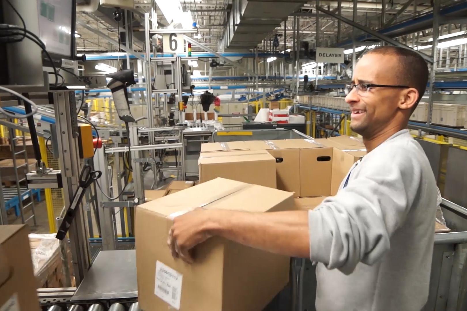 Colleague carrying a box in a WBA distribution center