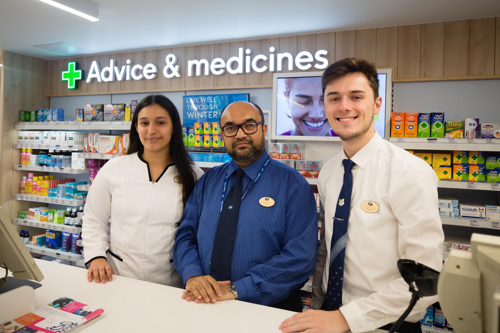 Three colleagues from Boots in the UK standing behind the in store pharmacy counter
