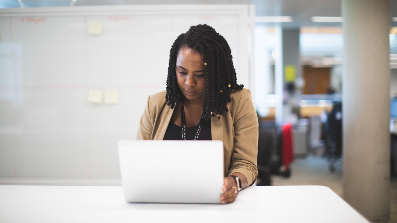 Team member working on laptop sitting at a desk.