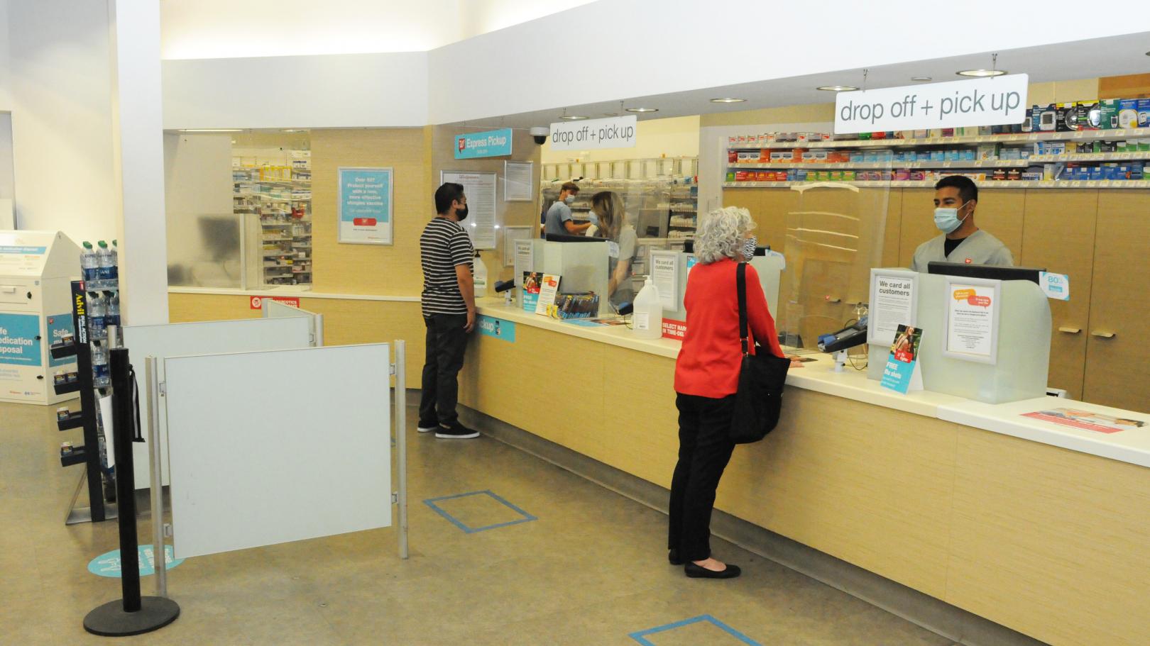 Customer talking to a Walgreens team member at the drugstore counter.