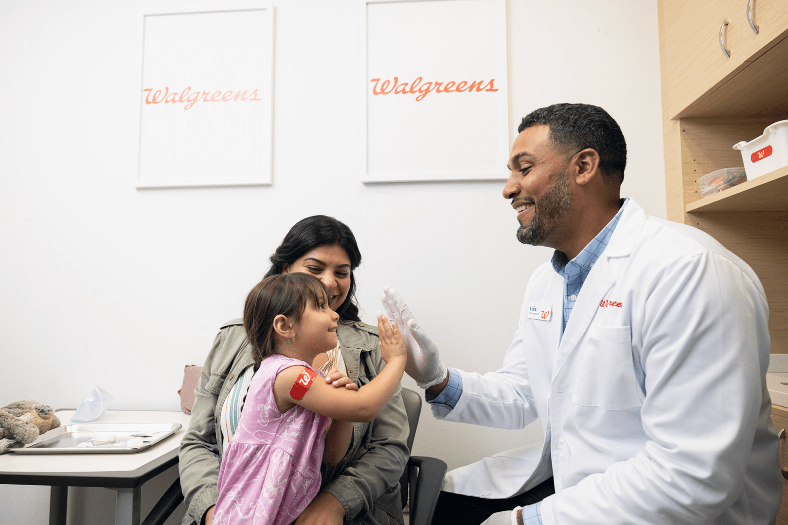 Young patient high-fives pharmacist after vaccination