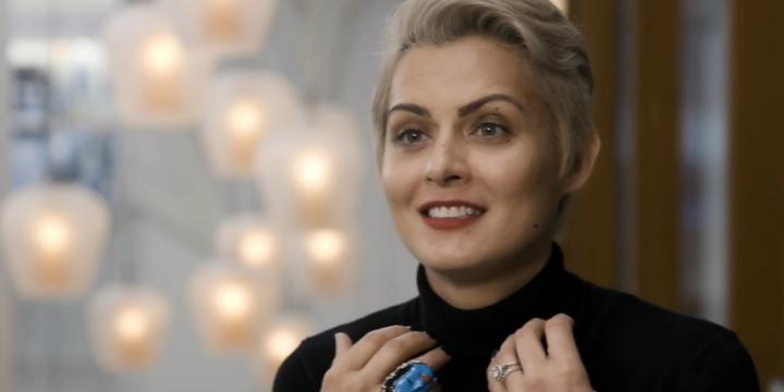 Head and shoulders of a smiling woman in a room