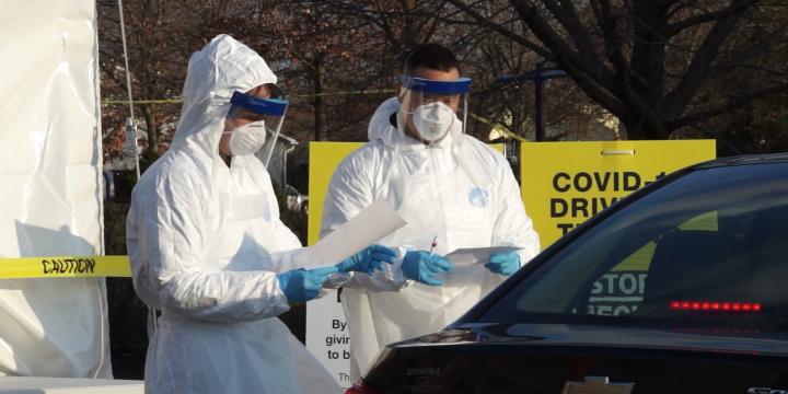 Workers at a drive thru testing facility