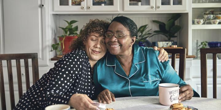 Middle aged woman side-hugging an older woman