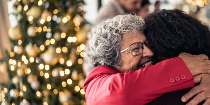 Women embracing by Christmas tree
