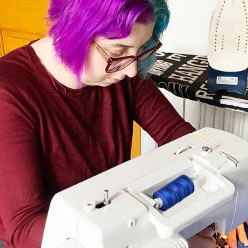 Elise at sewing machine making face masks