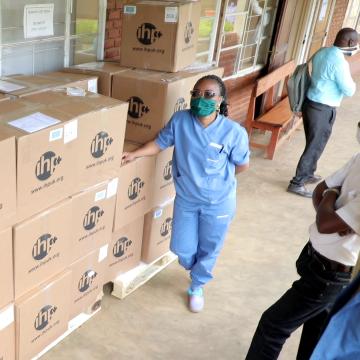 International Health Partners charity volunteer handling boxes with donations