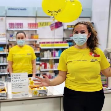 Employees holding balloons for Daffodil Day.